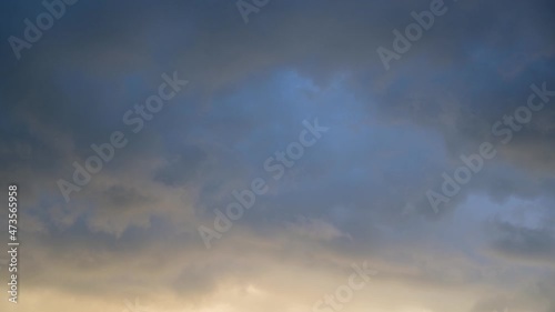 Timelapse of the sky. Gray clouds are moving in the sky. The blue sky looks through the gray clouds.