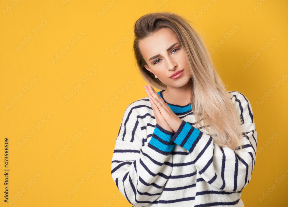 Please. Prayer woman holds her hands in a prayer gesture, begging for something, isolated on yellow background. Please concept Please. Prayer woman holds her hands in a prayer gesture, begging for something, isolated on yellow background. Please concept