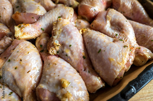 raw chicken drumsticks on baking tray prepared for oven