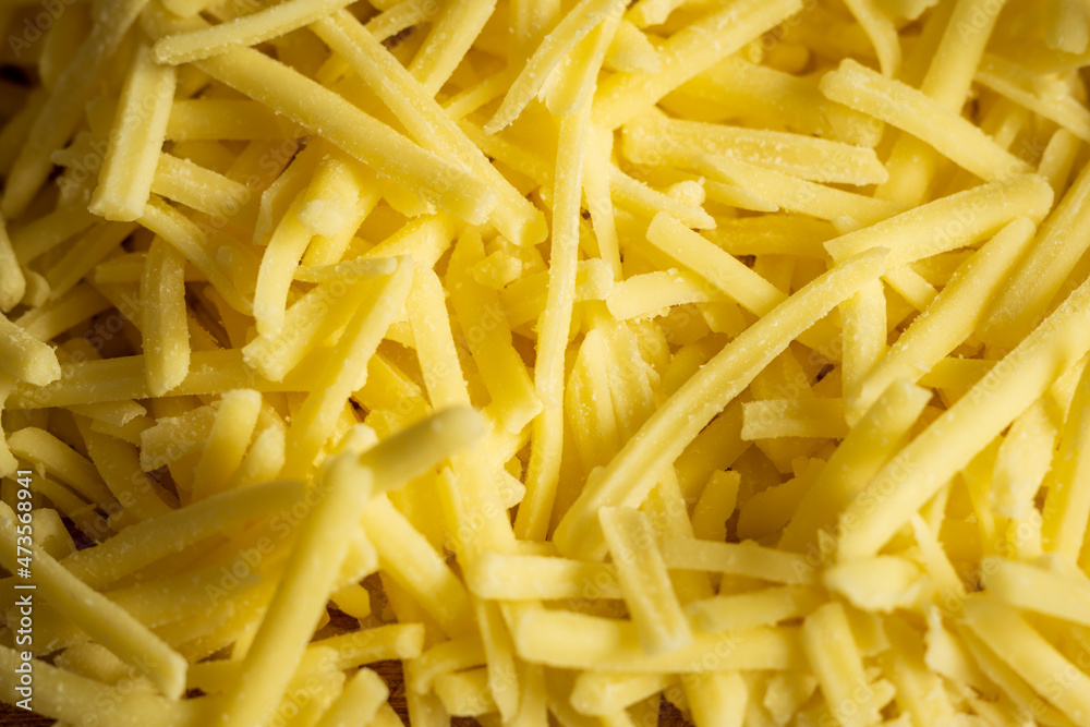 grated cheddar cheese background closeup grated cheddar cheese background closeup