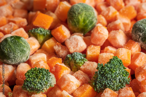 Frozen carrots broccoli and brussel sprout pieces closeup background