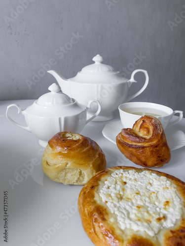 Cup of hot tea with delicious buns for tea party on cold morning