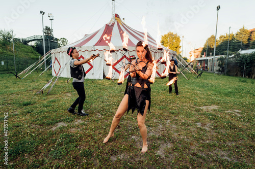 Male and female fire dancers practicing at circus photo