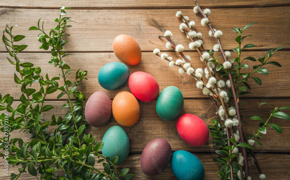 Easter eggs, boxwood and pussy willow branches. Easter composition on wooden background.