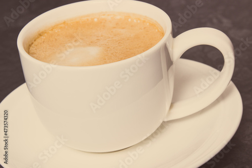 Cup of coffee with milk on dark background