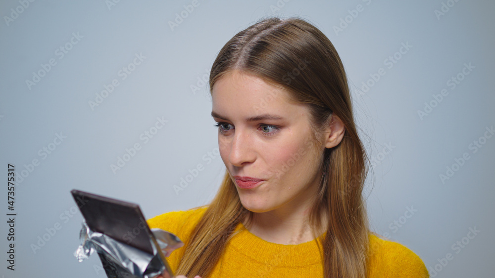 Portrait of smiling woman looking with chocolate bar at camera indoors Portrait of smiling woman looking with chocolate bar at camera indoors