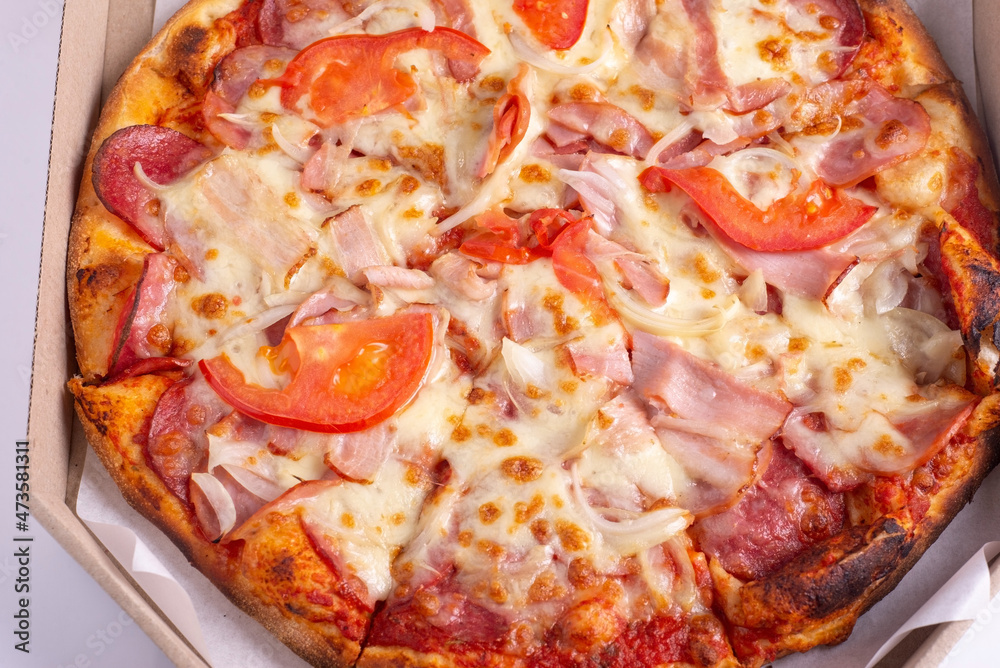 burnt meat pizza in a box on a white background
