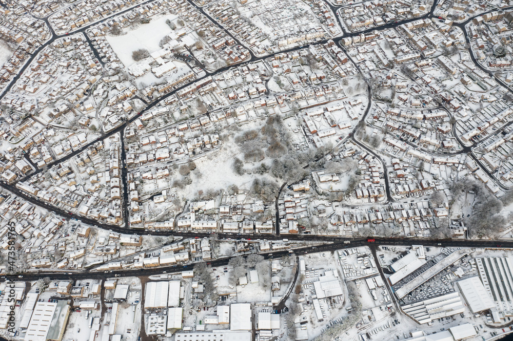 Straight down aerial photo in the winter time on a snowy day of the British town of Mirfield in Kirklees, West Yorkshire, England showing residential housing estates homes with snow covered roofs Straight down aerial photo in the winter time on a snowy day of the British town of Mirfield in Kirklees, West Yorkshire, England showing residential housing estates homes with snow covered roofs
