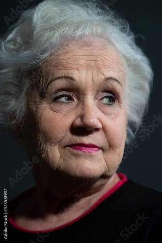 portrait of a blonde grandmother close-up on a dark background