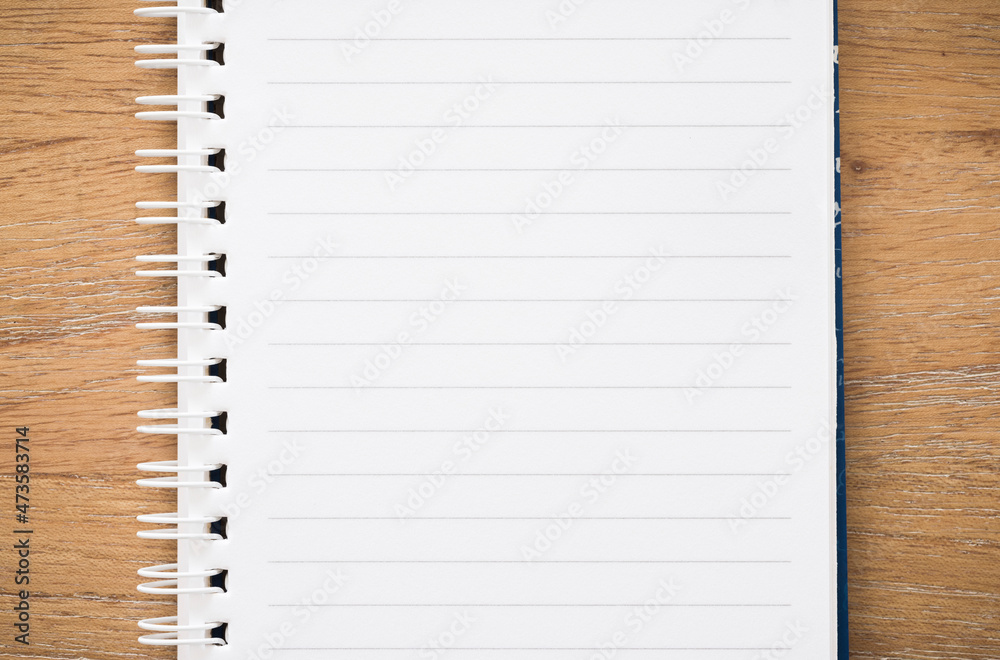 Lined notebook on wooden desk, white spiral bound Lined notebook on wooden desk, white spiral bound