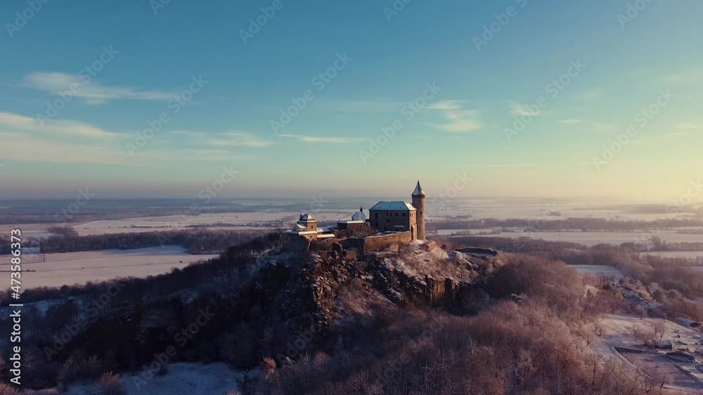 Aerial, early morning view of the Castle standing on the hill above fog at sunrise, light by morning sun rays. Aerial, early morning view of the Castle standing on the hill above fog at sunrise, light by morning sun rays.