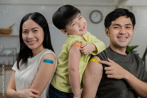 Leinwand Poster Group portrait photo of young Asian family after received covid-19 vaccine showing arm with plaster of covid-19 vaccinated, Adhesive bandage on arm after injection of vaccine concept