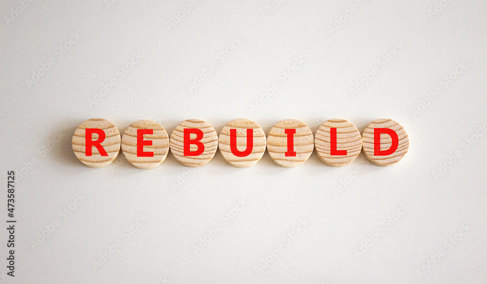 Rebuild and build symbol. The concept word Rebuild on wooden circles. Beautiful white background, copy space. Business rebuild and build concept. Rebuild and build symbol. The concept word Rebuild on wooden circles. Beautiful white background, copy space. Business rebuild and build concept.