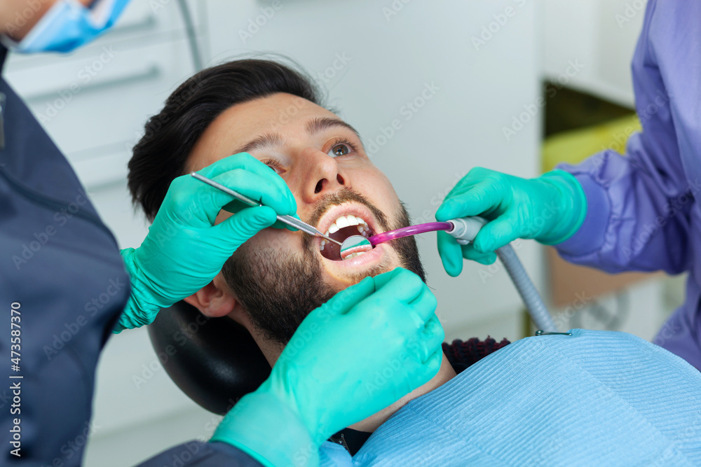 Ταπετσαρία Female dentist examines a man patient in a dental office using professional tools and personal protective equipment