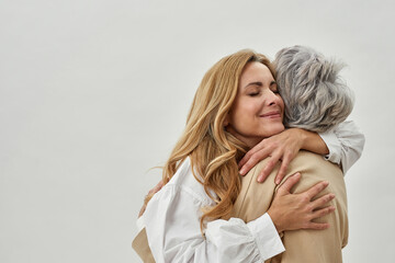 Loving adult daughter embrace old mother feel grateful