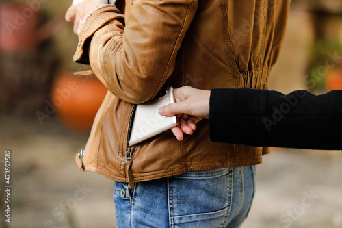 Pickpocket thief is stealing smartphone outdoors photo