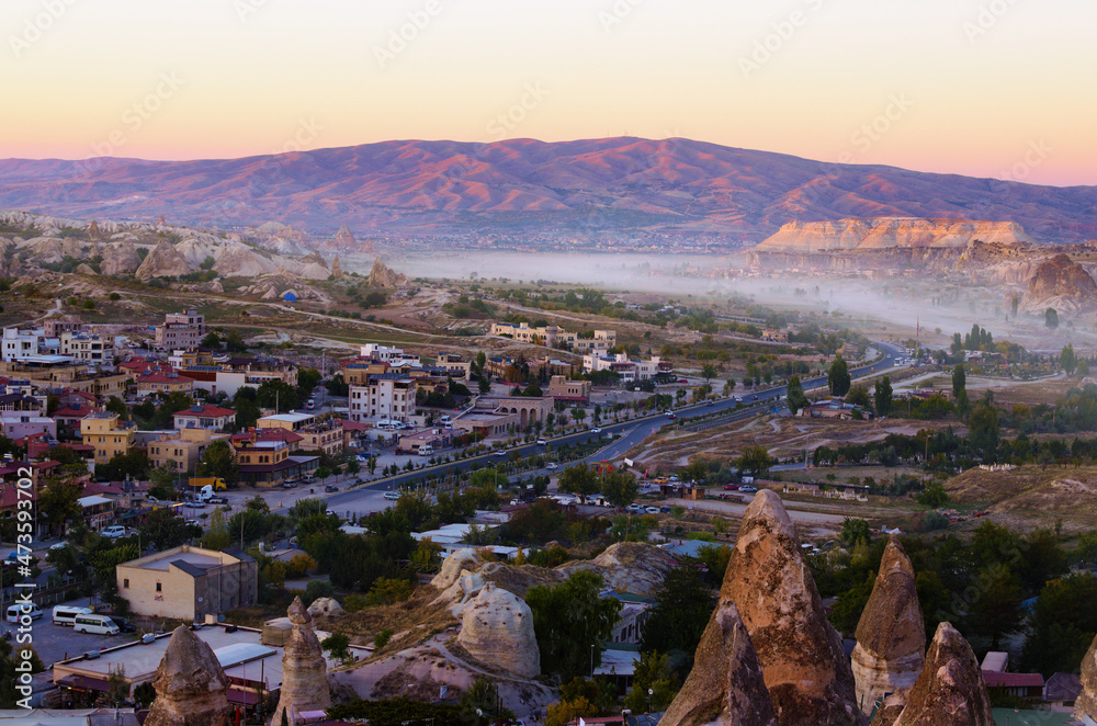 Sunset landscape view of ancient Goreme in Cappadocia. Amazing cave houses in shaped sandstone rocks. Popular travel destination in Turkey. UNESCO World Heritage Site