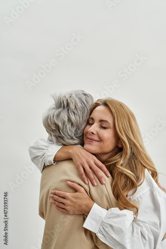 Loving grownup daughter embrace mature mother
