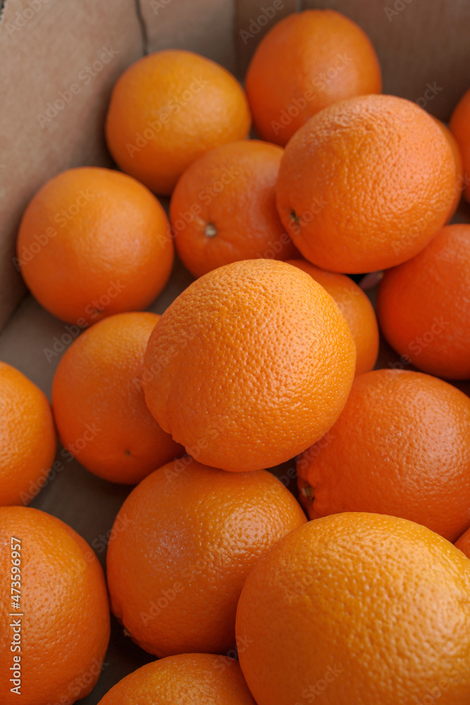 fresh oranges on the market. juicy vitamin fruits in a cardboard box fresh oranges on the market. juicy vitamin fruits in a cardboard box