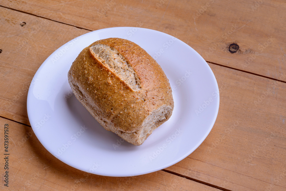 French rolls. Brazilian breads on a white plate on wooden table. French rolls. Brazilian breads on a white plate on wooden table.