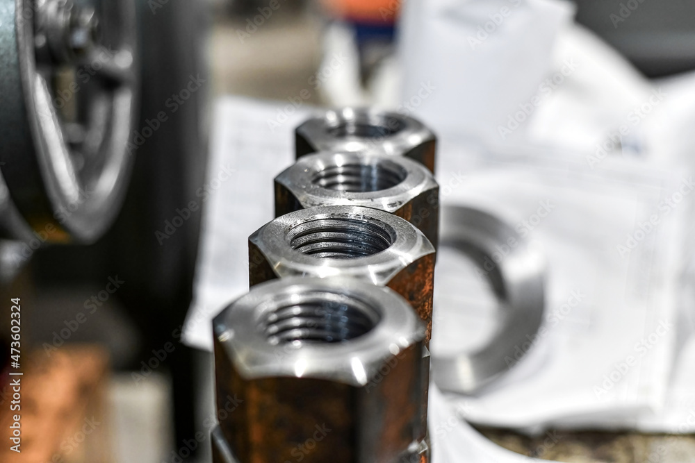 Several piled-up rusty nuts lie in the workshop.