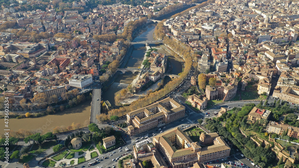 Obraz premium Aerial drone photo of Tiber island or Isola Tiberina, a small island in a bend of the River Tiber with a number of historical buildings and monuments, Rome historic centre, Italy