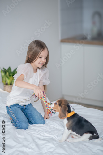 Female child using a rope toy during the dog training