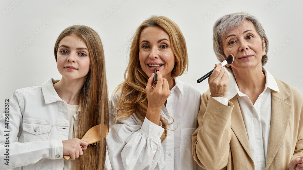 Portrait of smiling three generations of women do makeup Portrait of smiling three generations of women do makeup