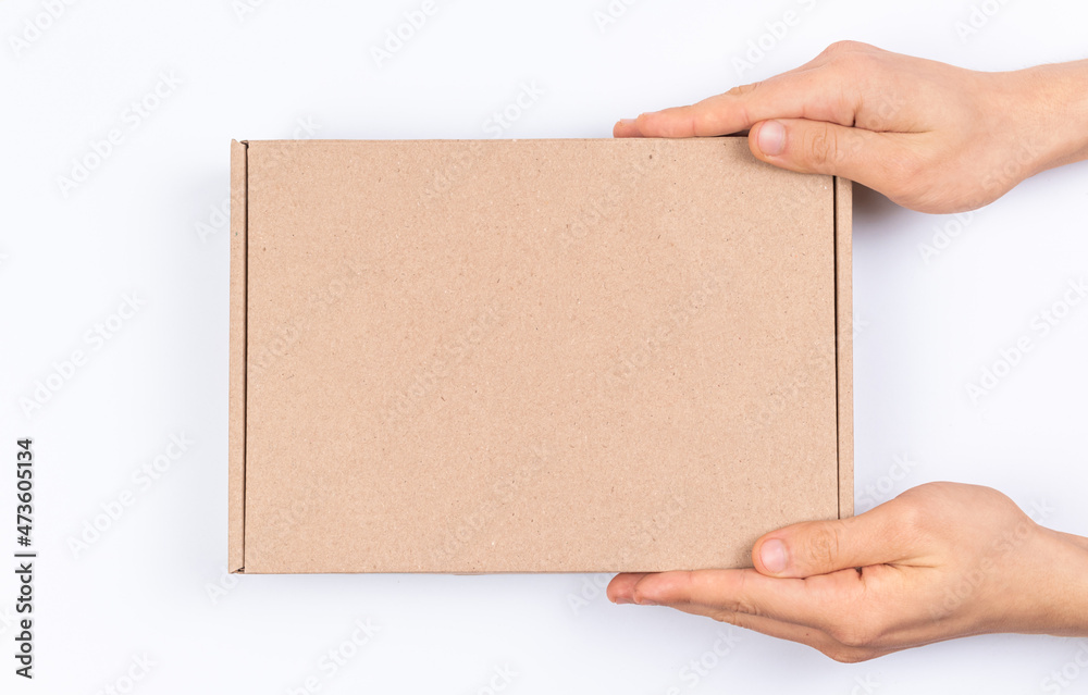 Brown cardboard box in delivery man hands, mockup, on a white background, top view photo Brown cardboard box in delivery man hands, mockup, on a white background, top view photo