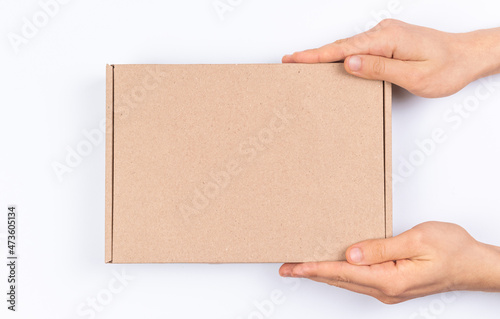 Brown cardboard box in delivery man hands, mockup, on a white background, top view photo © FellowNeko
