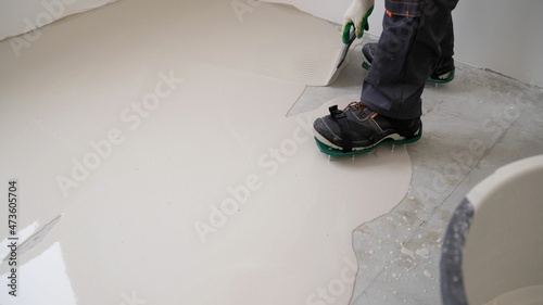 Spreading self leveling compound with trowel. Self-leveling epoxy. Leveling with a mixture of cement floors. Leveling liquid floors with a trowel.