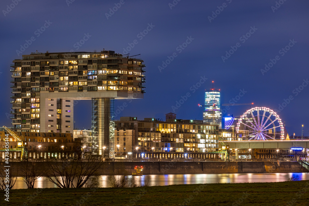 Fototapeta premium Illuminated buildings against Cologne winter skyline
