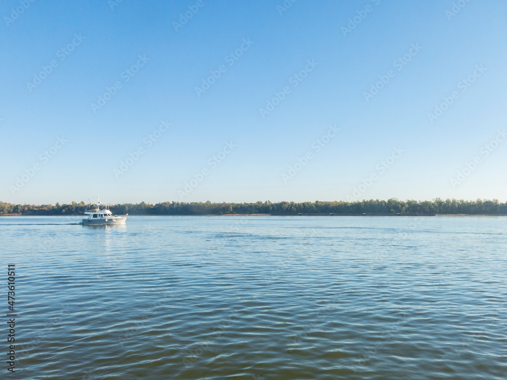 A boat in the Ohio River on a clear morning with blue water.
