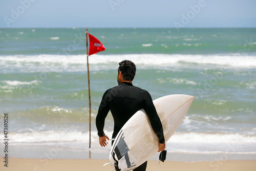 surfer goes riding waves in Brazil. Surfing action water board sport. Men catching waves in ocean, isolated. Young people sports lessons and beach activity on summer vacation