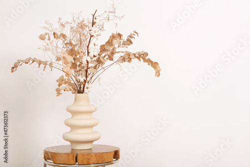 Dry brown flowers in beige vase