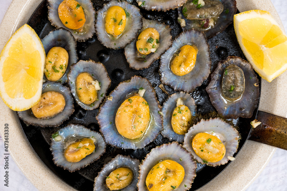 tasty seafood - grilled limpets served with lemon. Stock Photo | Adobe Stock