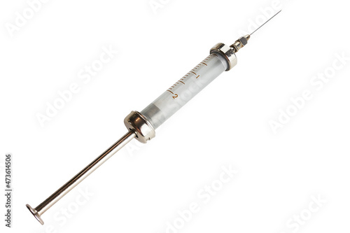 Old vintage glass metal reusable medical syringe close-up on the white background. Retro medical instrument, isolated.