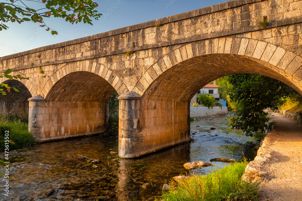 Stone bridge on the lower reaches of the river Zrnovnica, near Split town in Croatia, Europe.