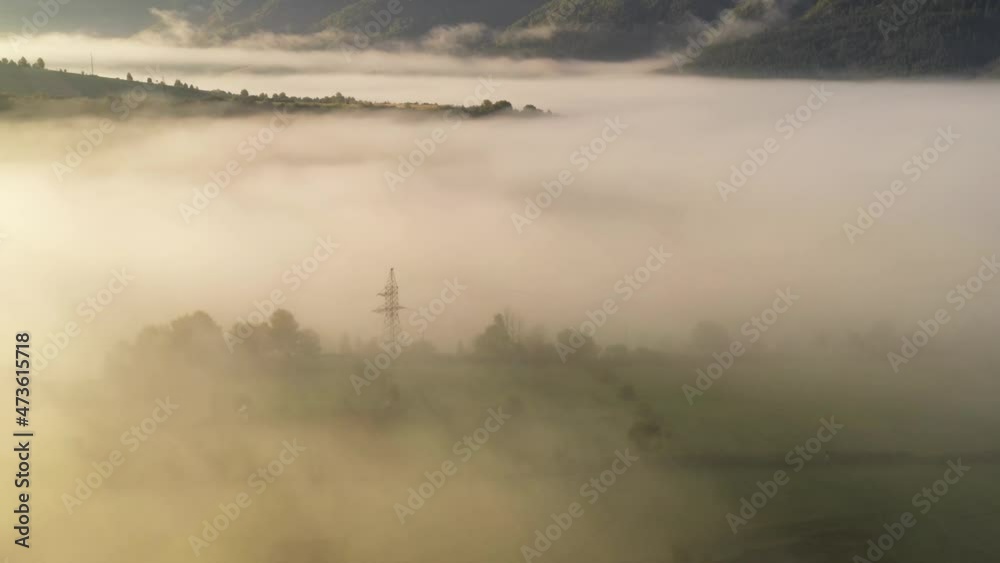 Aerial view on amazing flowing morning fog spreads over green meadows in autumn mountains. Ukrainian Carpathian mountains. UHD 4k video
