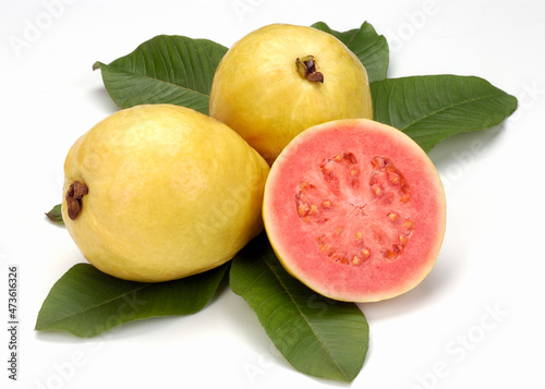 Guavas, split in half and leaves on white background. Tropical fruit.