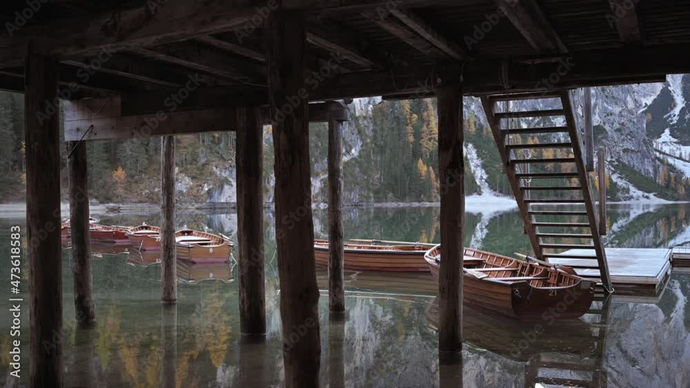 Famous lake Braies in autumn Dolomites mountains. Wooden boats and pier in clear water of Lago di Braies, Dolomite Alps, Italy. Calming morning scene. UHD 4k video Famous lake Braies in autumn Dolomites mountains. Wooden boats and pier in clear water of Lago di Braies, Dolomite Alps, Italy. Calming morning scene. UHD 4k video