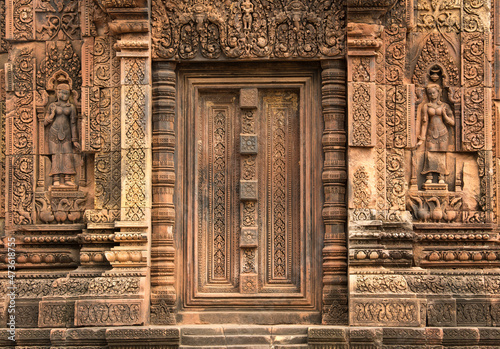 Intricately carved sandstone door and walls of Banteay Srei temple in the Angkor region of Cambodia. Built in 10th cenury. Dedicated to the Hindu god Shiva. photo