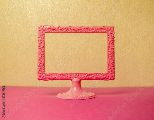 light pink photo frame on a stand on a yellow background space for text photo