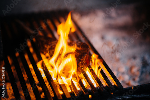 Juicy steak is grilled in a restaurant. Roasting meat in the fire on the grill.