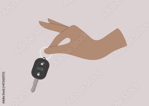 A rental service, a  hand holding a remote control vehicle key, a car-sharing concept