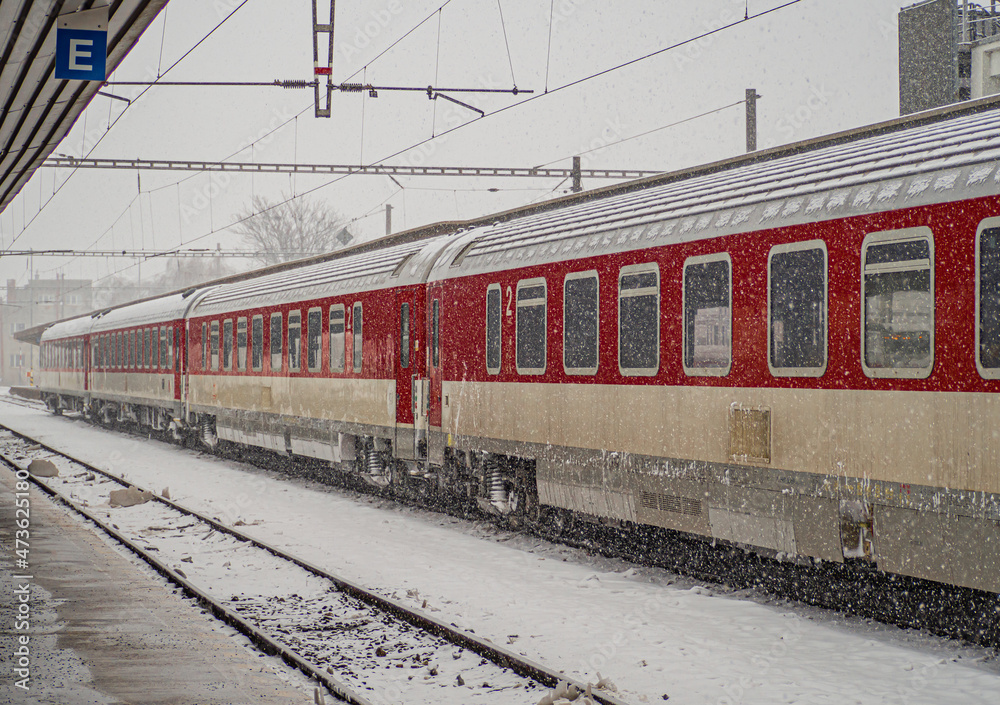 Fototapeta premium A snow-covered railway platform with a passenger train.