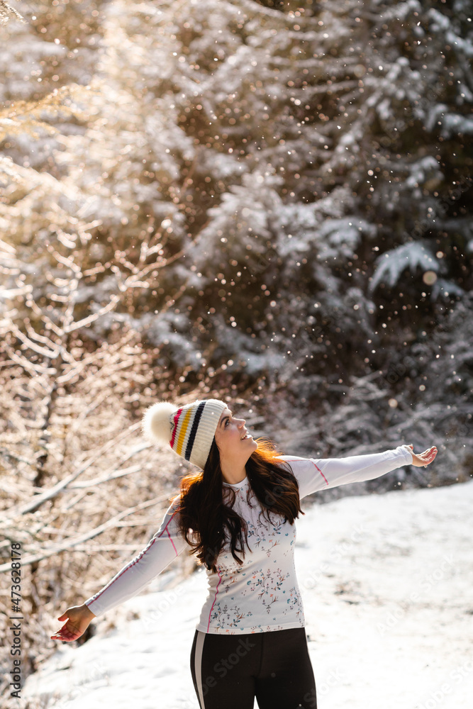 Woman catching snowflakes with tongue in winter snow scene