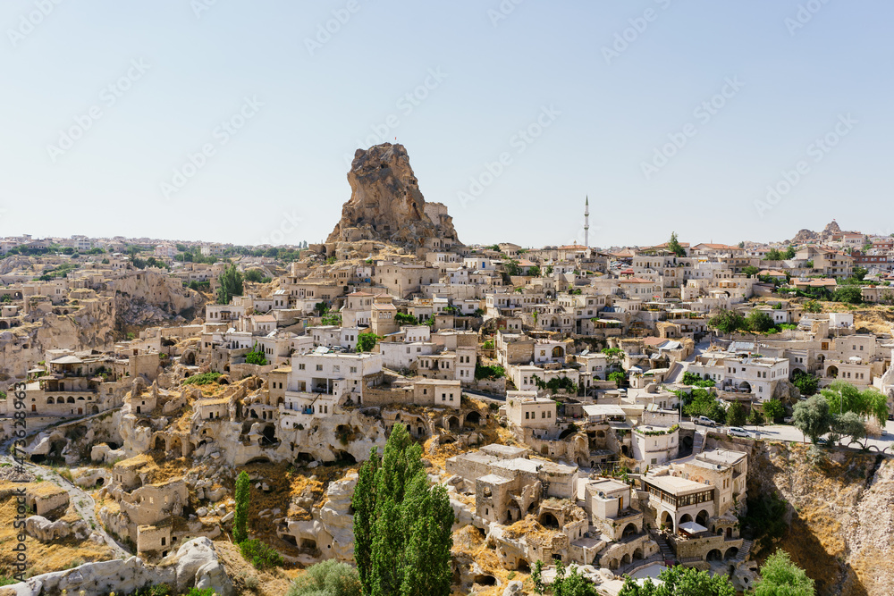 Cappadocia, Turkey - 20 July 2021. Day view of Goreme town with blue clear sky on horison. Famous center of balloon fligths