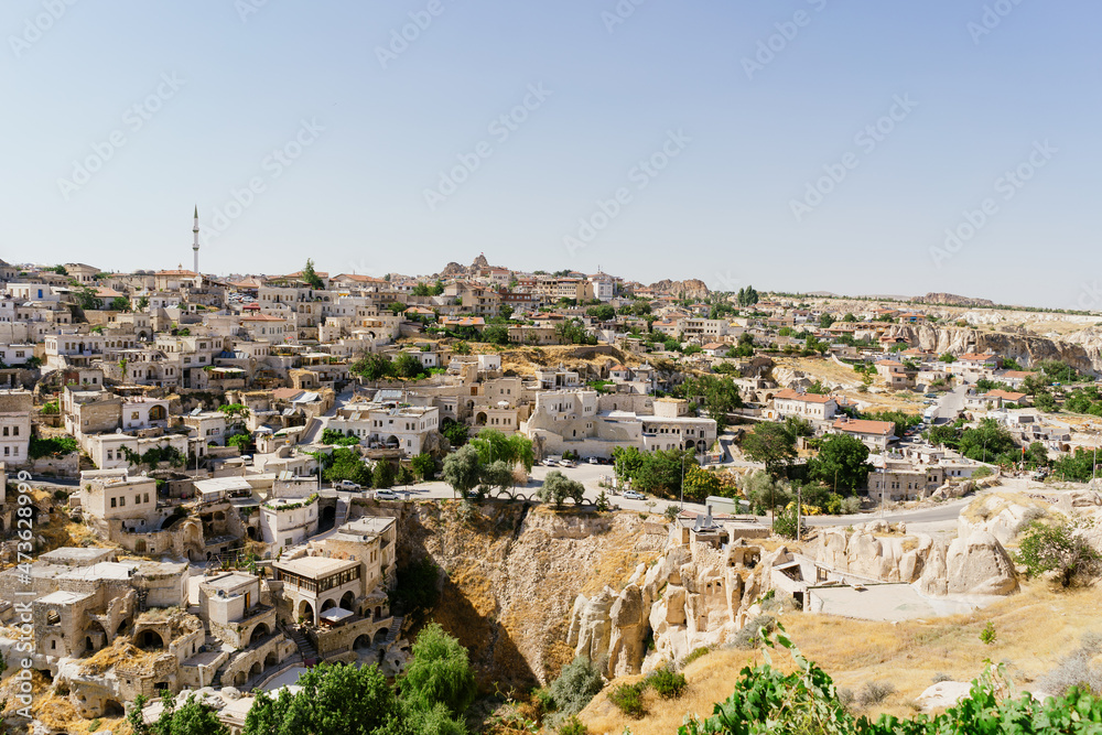 Cappadocia, Turkey - 20 July 2021. Day view of Goreme town with blue clear sky on horison. Famous center of balloon fligths