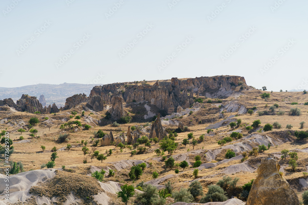 Picturesque summer view Scenic on landscape view of geologic formations of Cappadocia. Amazing shaped sandstone rocks. Famous touristic place and romantic travel destination.. Picturesque summer view Scenic on landscape view of geologic formations of Cappadocia. Amazing shaped sandstone rocks. Famous touristic place and romantic travel destination..